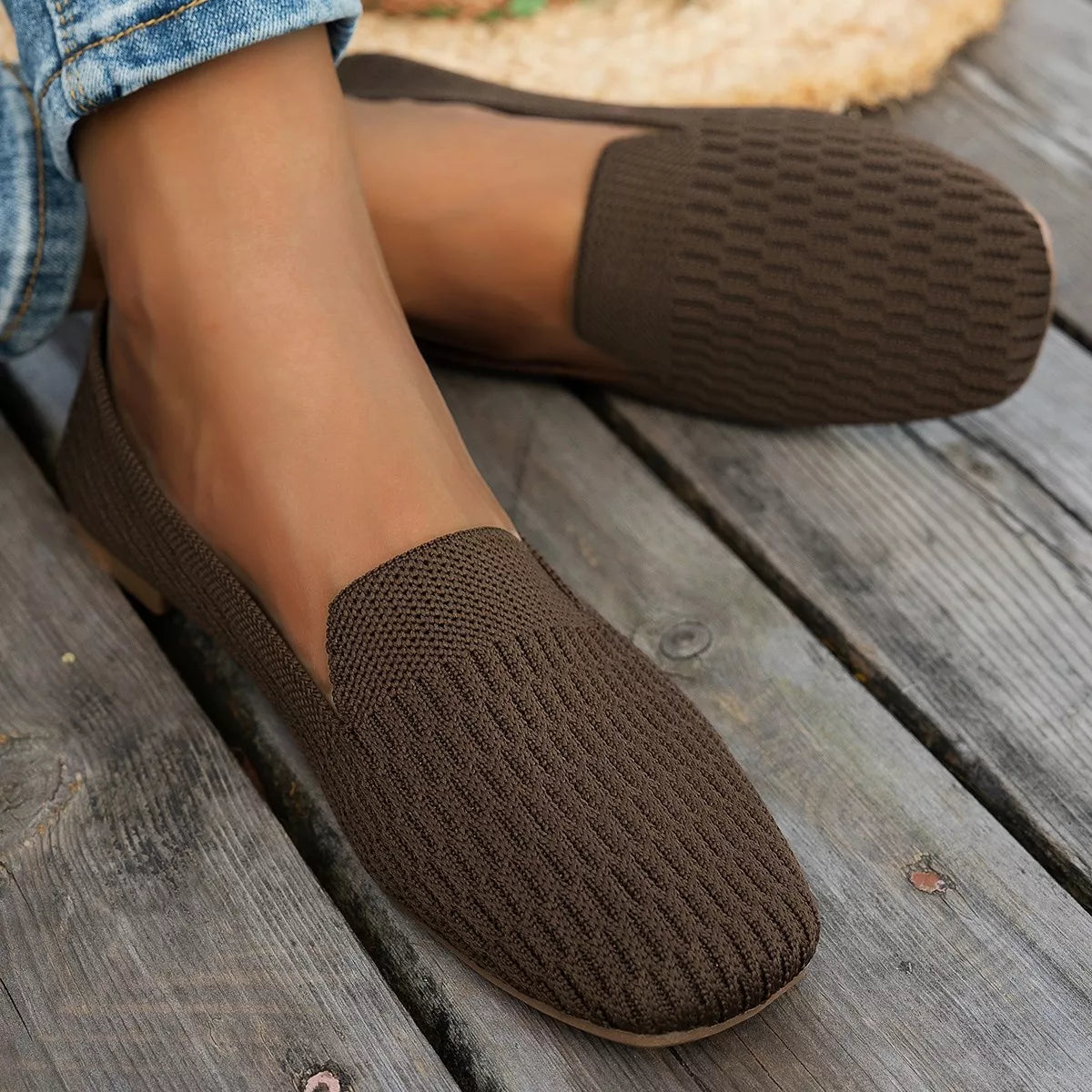 Brown textured slippers worn on a wooden floor