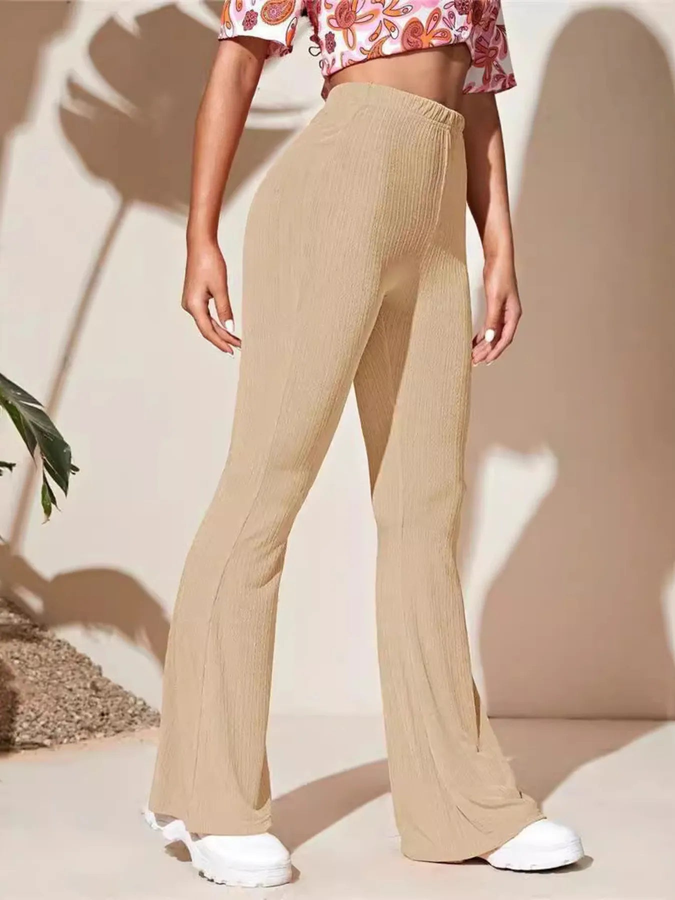 Person wearing beige wide-leg pants with a neutral background