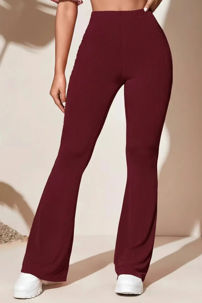 Person wearing maroon pants with a neutral background