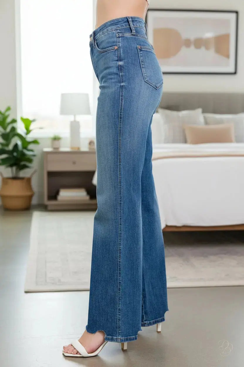 Blue jeans worn by a person on a plain background