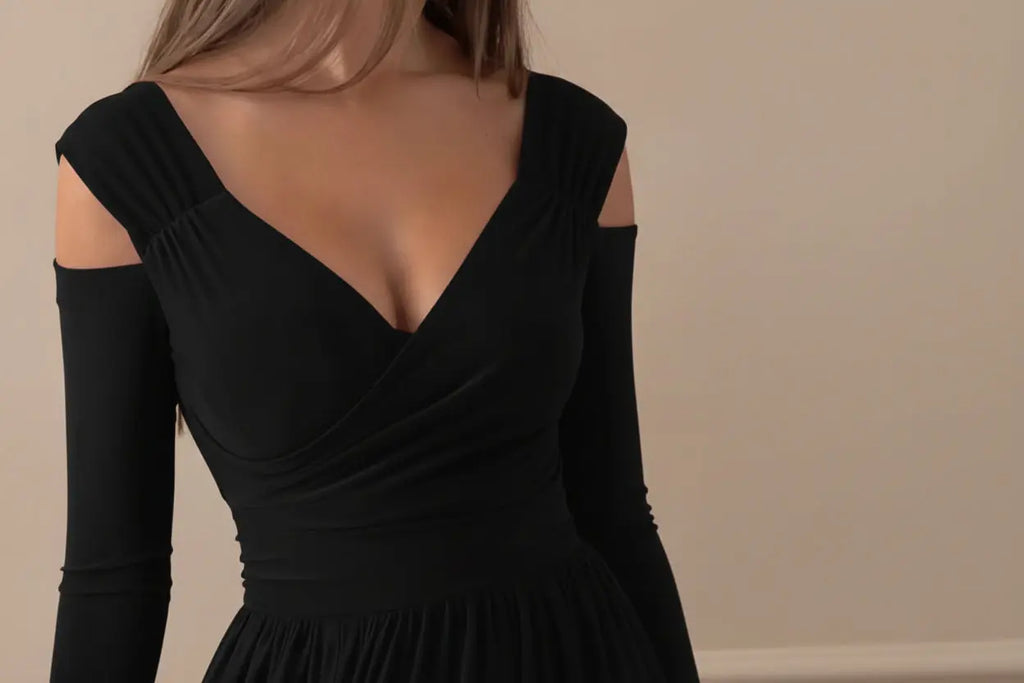 Black dress with long sleeves and a V-neckline, worn by a person.