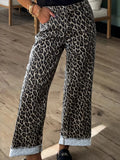 Leopard print pants worn by a person on a wooden floor.