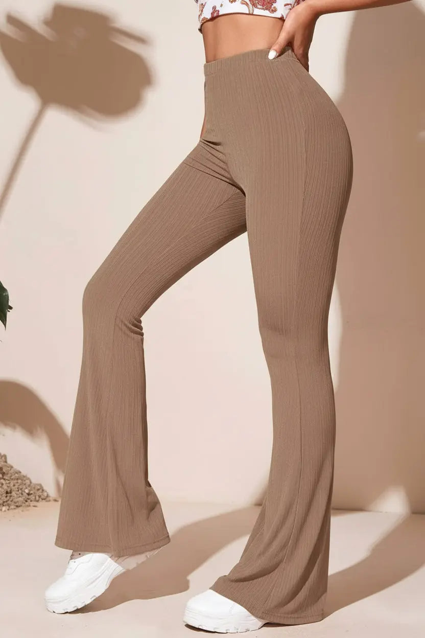 brown ribbed pants worn by a person in a tan background outside, with her hand on her hip