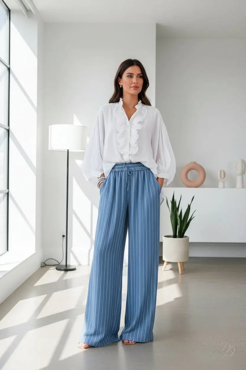 Person wearing blue striped pants and a white shirt on a wooden floor.