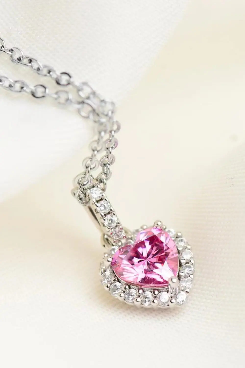 Necklace with a pink heart-shaped gemstone pendant on a light background