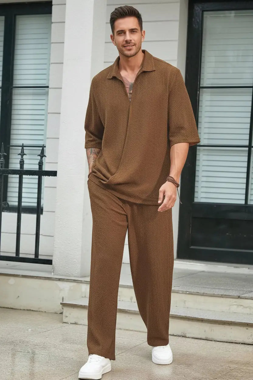 Man wearing a brown outfit standing on a sidewalk.